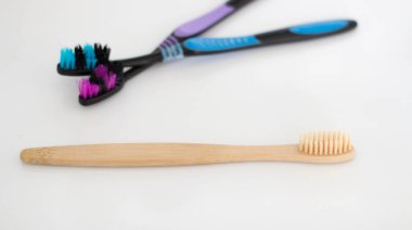 Bulanık arkaplanda pamuk tomurcukları olan organik biyolojik çözünebilir bambu diş fırçası..