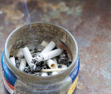 Açık Metal Sigara Kovası ve Çöpe atılmış Sigara Popoları Kumda