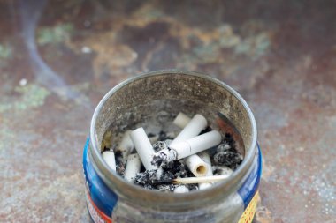 Açık Metal Sigara Kovası ve Çöpe atılmış Sigara Popoları Kumda