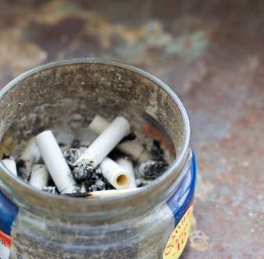 Açık Metal Sigara Kovası ve Çöpe atılmış Sigara Popoları Kumda