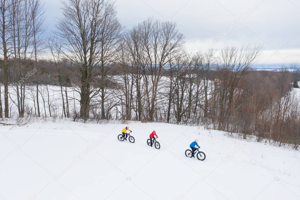 Aerial drone photo of a group of friends riding their fat bike in the snow in Ontario, Canada