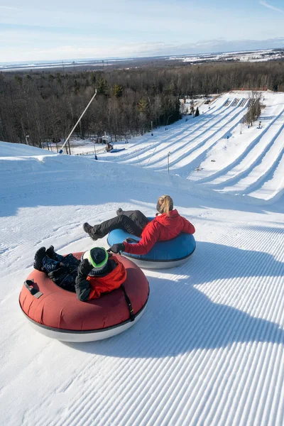 Beautiful woman snow tubing with her son in the winter in Canada