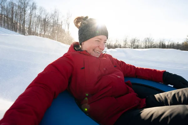 Beautiful woman snow tubing in the winter in Canada