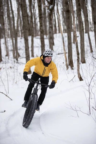 Человек едет на своем жирном велосипеде по снегу — стоковое фото