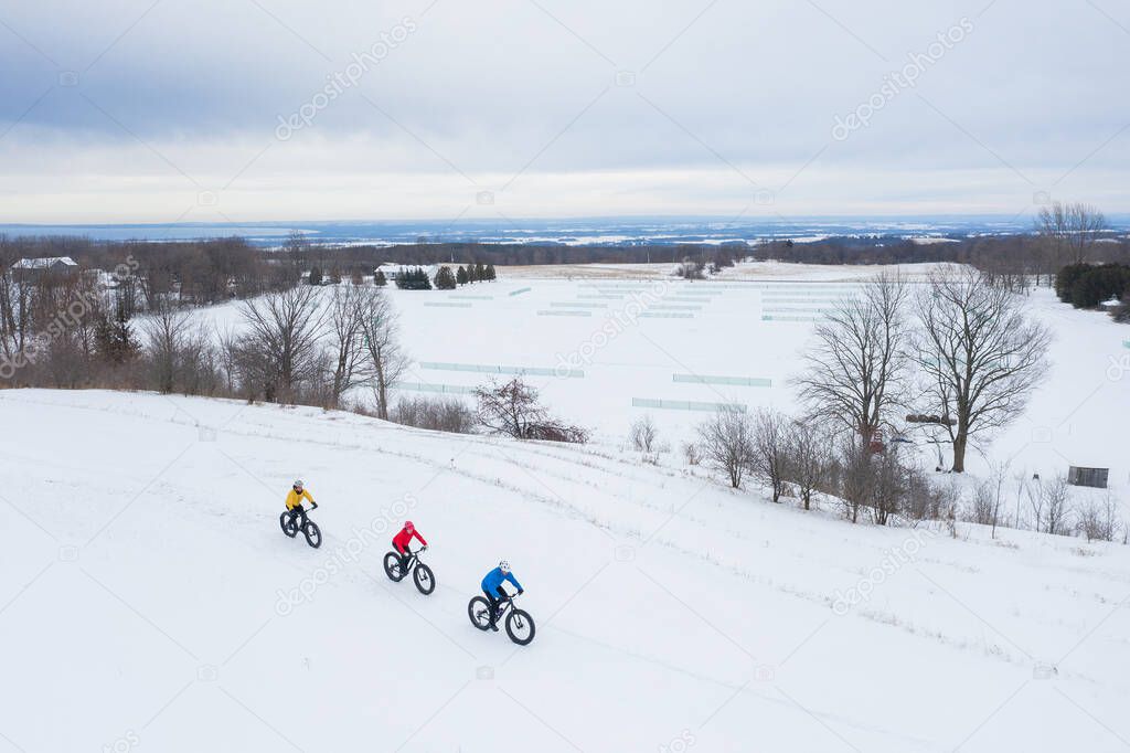 Aerial drone photo of a group of friends riding their fat bike in the snow in Ontario, Canada