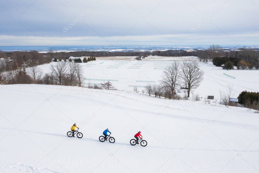 Aerial drone photo of a group of friends riding their fat bike in the snow in Ontario, Canada
