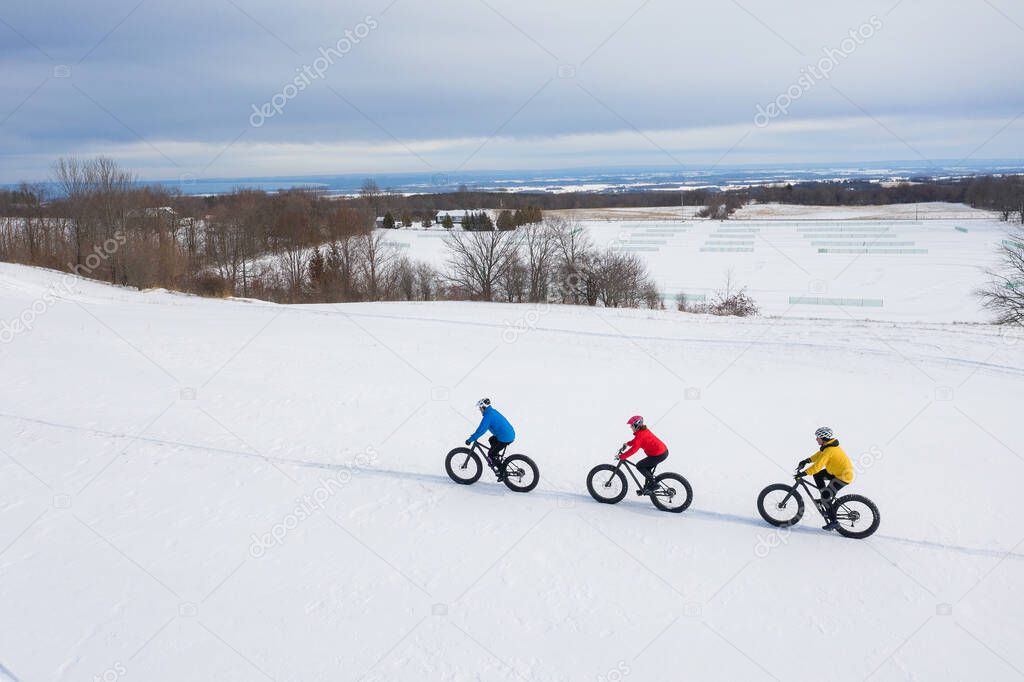 Aerial drone photo of a group of friends riding their fat bike in the snow in Ontario, Canada