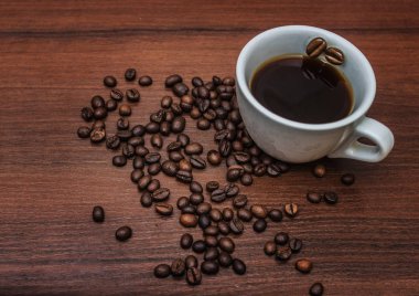 Fincan kahve kahve çekirdekleri ile bir ağaç üzerinde