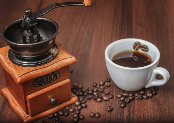 Bir fincan kahve ile bir kahve değirmeni bir ağaç üzerinde — Stok fotoğraf