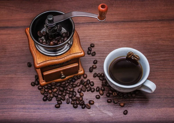 Una tazza di caffè con un macinino da caffè su un albero — Foto Stock