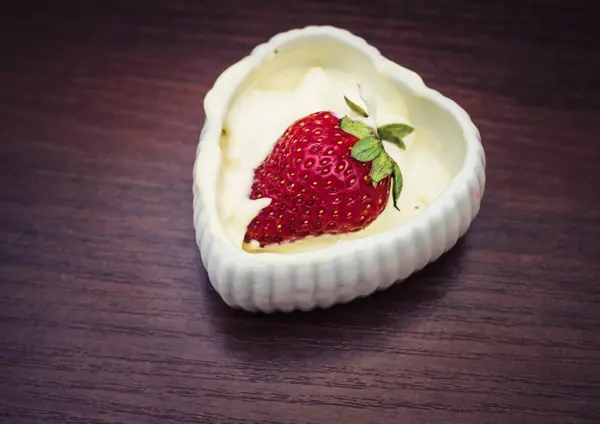 Strawberries in cream in the form of heart — Stock Photo, Image