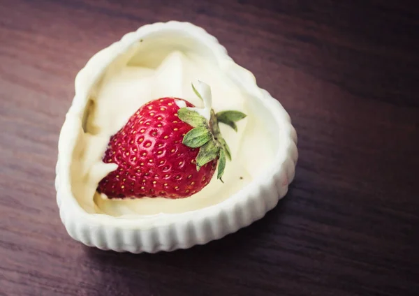 Strawberries in cream in the form of heart — Stock Photo, Image