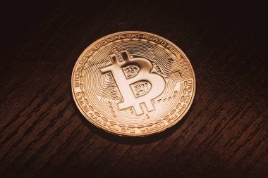 Koyu ahşap zemin üzerine altın bitcoin. Arka plan.