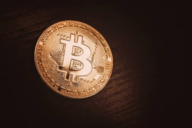 Koyu ahşap zemin üzerine altın bitcoin. Arka plan.