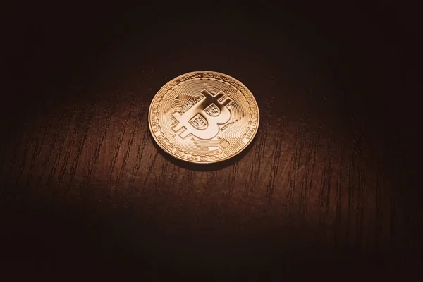 Golden bitcoin on a dark wooden background. Background. — Stock Photo, Image