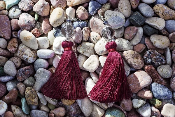 Earrings from thread on colored stones — Stock Photo, Image