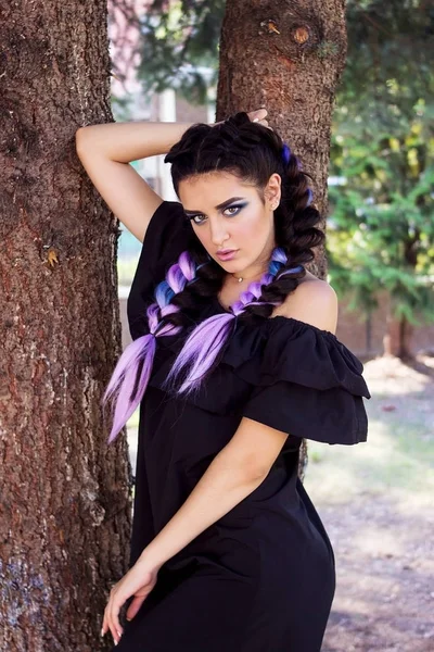 Bella ragazza bruna in posa vicino a un albero . — Foto Stock