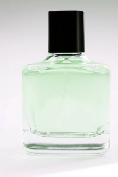 Скляна пляшка парфумів на світлому фоні — стокове фото