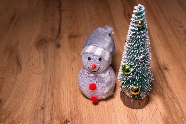 Noel ağacının yanında üç oyuncak kardan adam. Eğlenceli bir şirket.