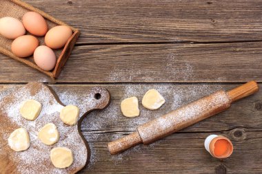 Açık mavi levha, taş ya da beton zemin üzerinde makarna ya da hamur köftesi yapmak için malzeme içeren mutfak arka planı. Kopya alanı olan üst görünüm..