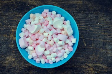 Eski bir ahşap masa üzerinde bir kasede renkli şekerleme