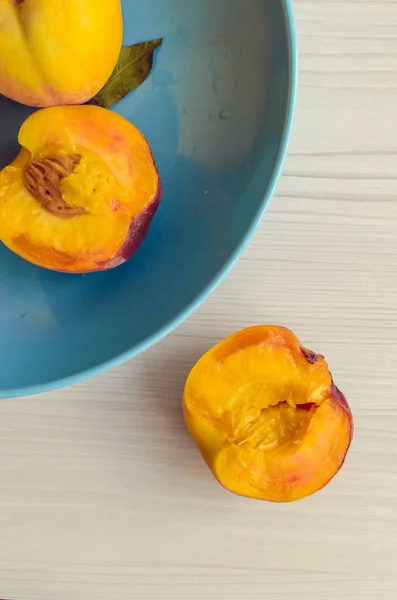 Ripe peaches in blue bowl