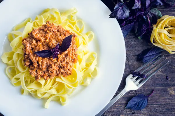 Pasta with bolognese sauce on wooden background — Stock Photo, Image