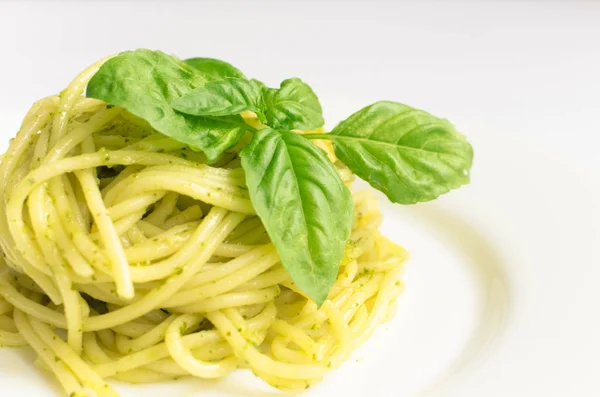 Esparguete de macarrão italiano com molho de pesto caseiro e folha de manjericão — Fotografia de Stock