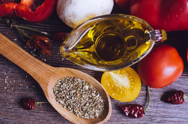 Olio d'oliva, pomodori ed erbe aromatiche sul tavolo di legno — Foto Stock