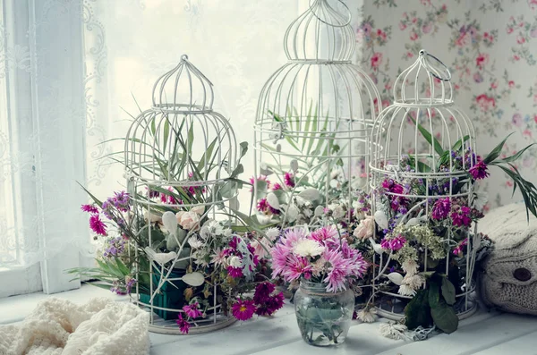 Pencerenin yakınındaki pembe ve mor çiçekler