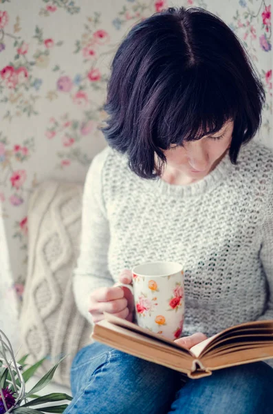 Красива жінка п'є гарячий чай і читає книгу — стокове фото