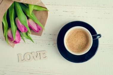 Fincan kahve kokulu pembe laleler ve ahşap kelime aşk