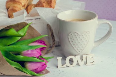 Kahve ay çöreği, buket pembe laleler ve ahşap kelime aşk ile