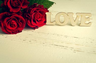 Kırmızı gül çiçekler ahşap kelime aşk ile