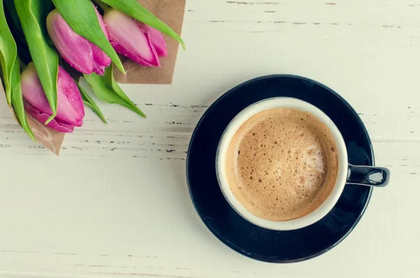 Cup of coffee with bouquet of pink tulips — Stock Photo, Image