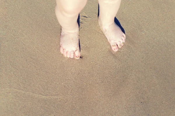 Beine von Kindern stehen am Strand — Stockfoto