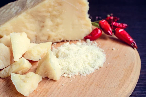 Queijo parmesão ralado em tábua de madeira — Fotografia de Stock