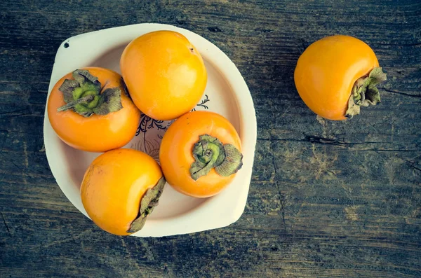 Delicious fresh persimmon fruit on wooden table — Stock Photo, Image
