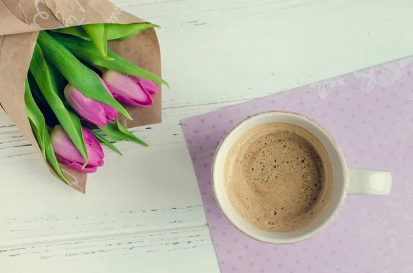 Kopp kaffe med bukett av rosa tulpaner — Stockfoto