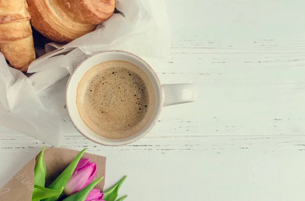 Fincan kahve kokulu pembe laleler ve kruvasan