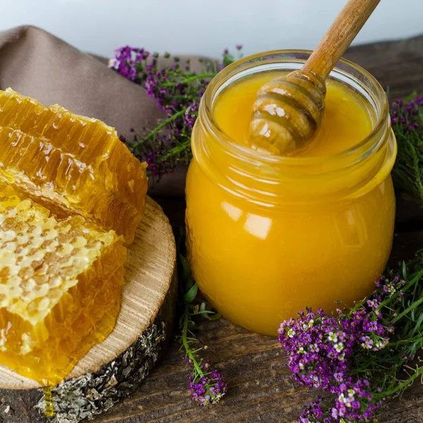 Pentes de mel e panela de vidro com mel — Fotografia de Stock