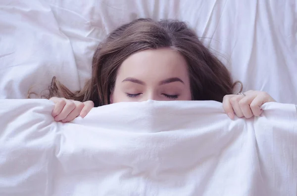 Красивая молодая женщина лежит в постели и спит — стоковое фото