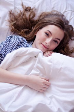 Mutlu genç kadın güneşli sabahın tadını çıkarıyor.