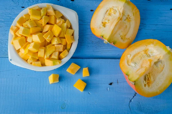 Autumn raw sliced pumpkin on blue wooden background — Stock Photo, Image