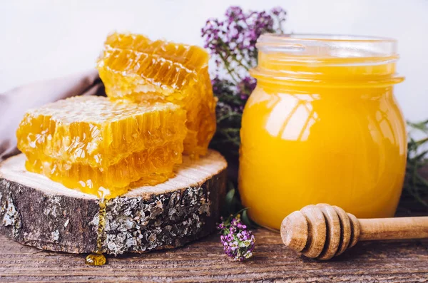 Соты и стеклянный горшок с медом — стоковое фото