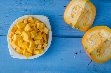 Sonbahar çiğ kabak mavi ahşap arka plan üzerine dilimlenmiş