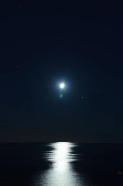 Luna llena sobre agua oscura con reflejos sobre ella —  Fotos de Stock