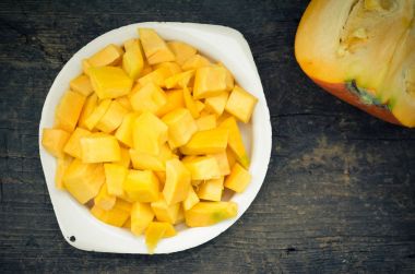 Sonbahar çiğ kabak rustik ahşap arka plan üzerine dilimlenmiş