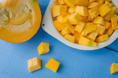 Sonbahar çiğ kabak mavi ahşap arka plan üzerine dilimlenmiş