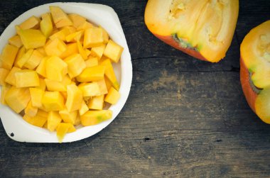 Sonbahar çiğ kabak rustik ahşap arka plan üzerine dilimlenmiş